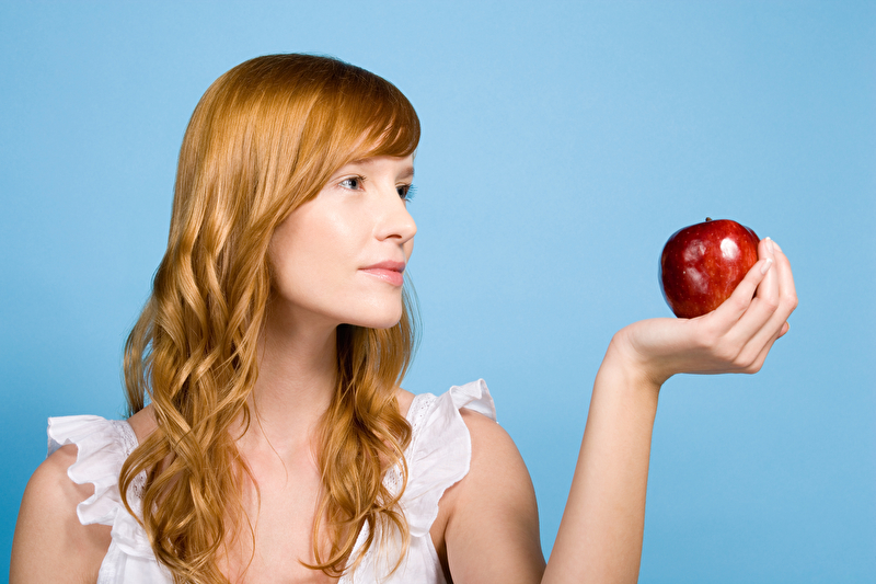 Frau hält einen Apfel