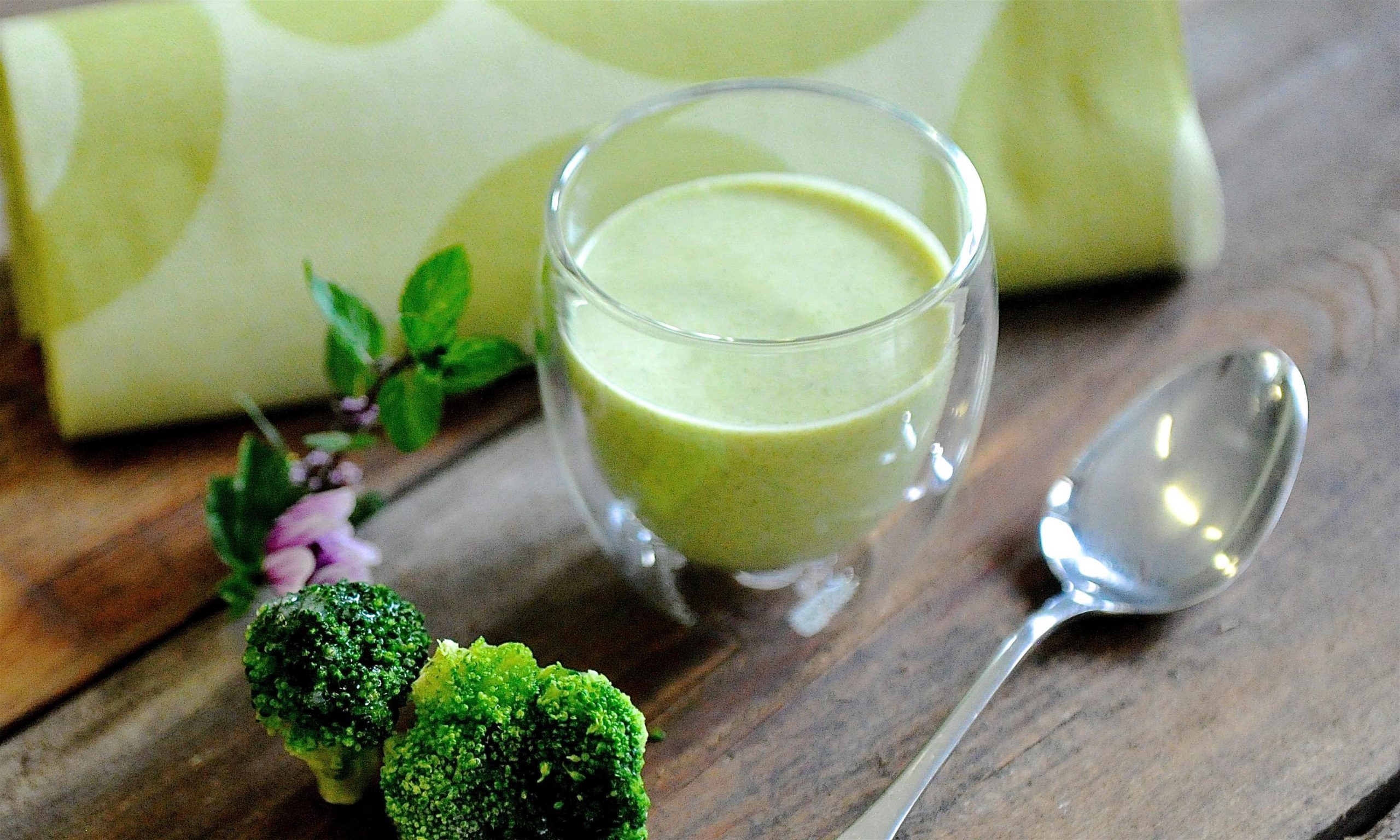 Green soup in a jar with broccoli and spoon