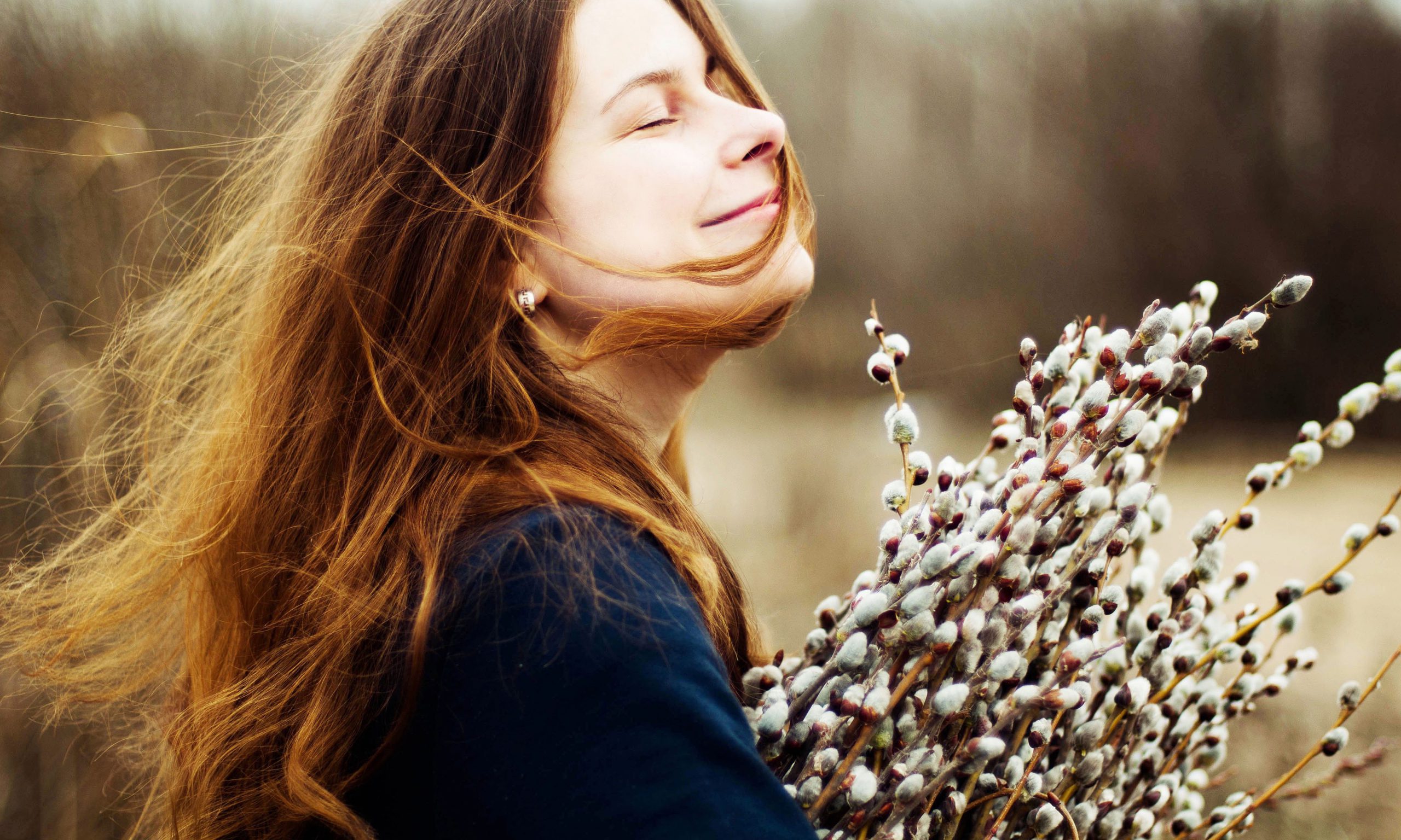 Porträt eines schönen jungen Mädchens mit einem riesigen Arm voller Weiden