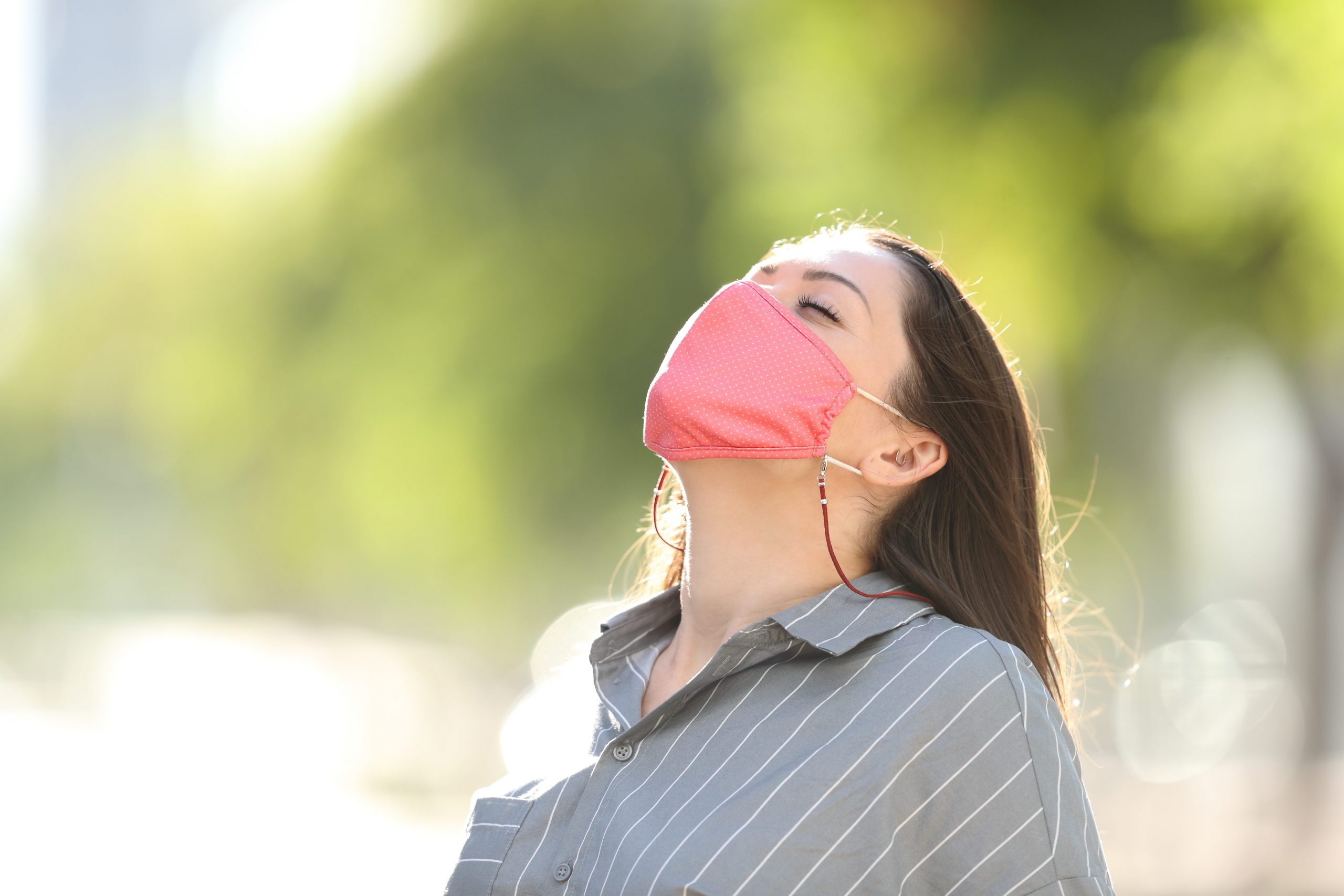 Woman wearing mask breathing fresh air in a park