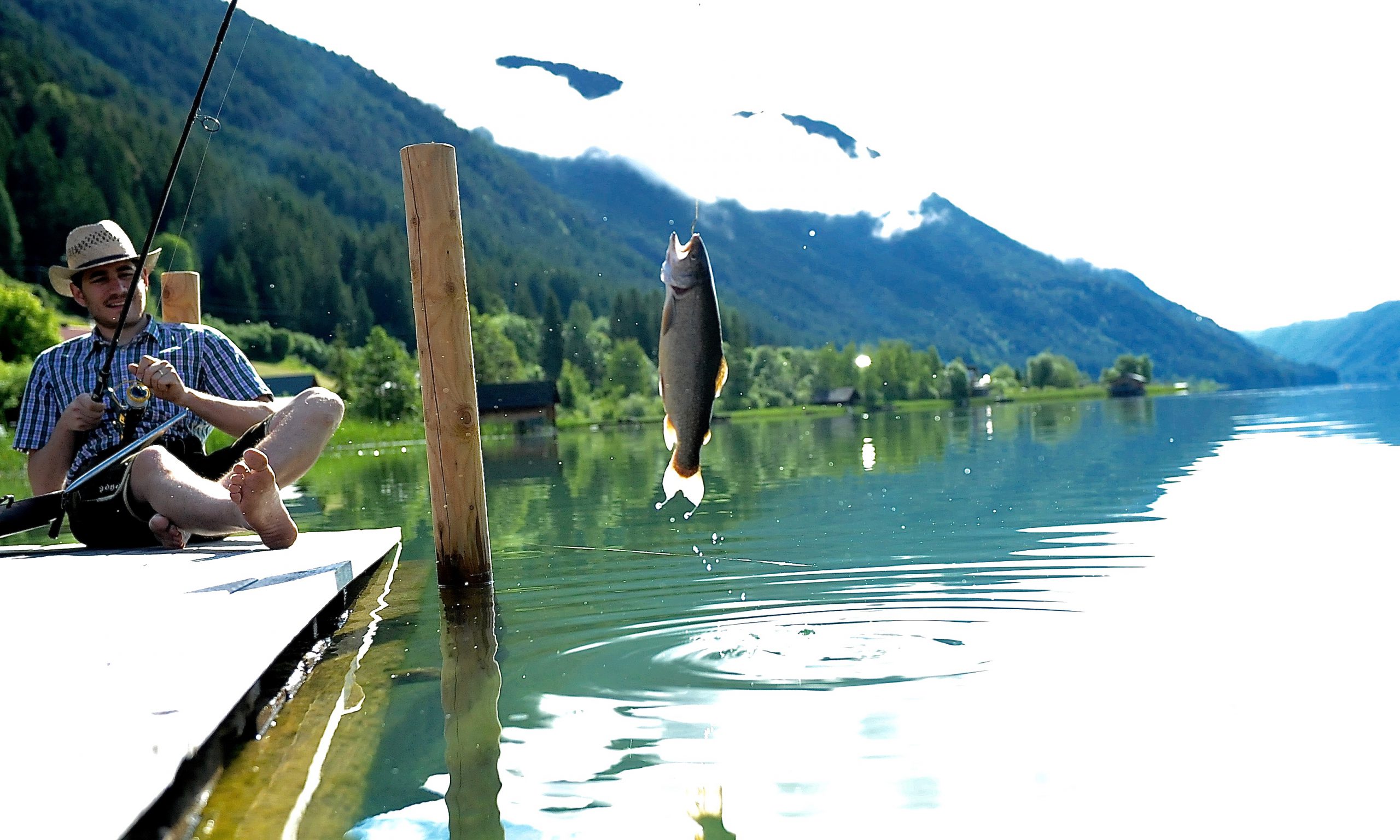 Junger Mann fischt am See