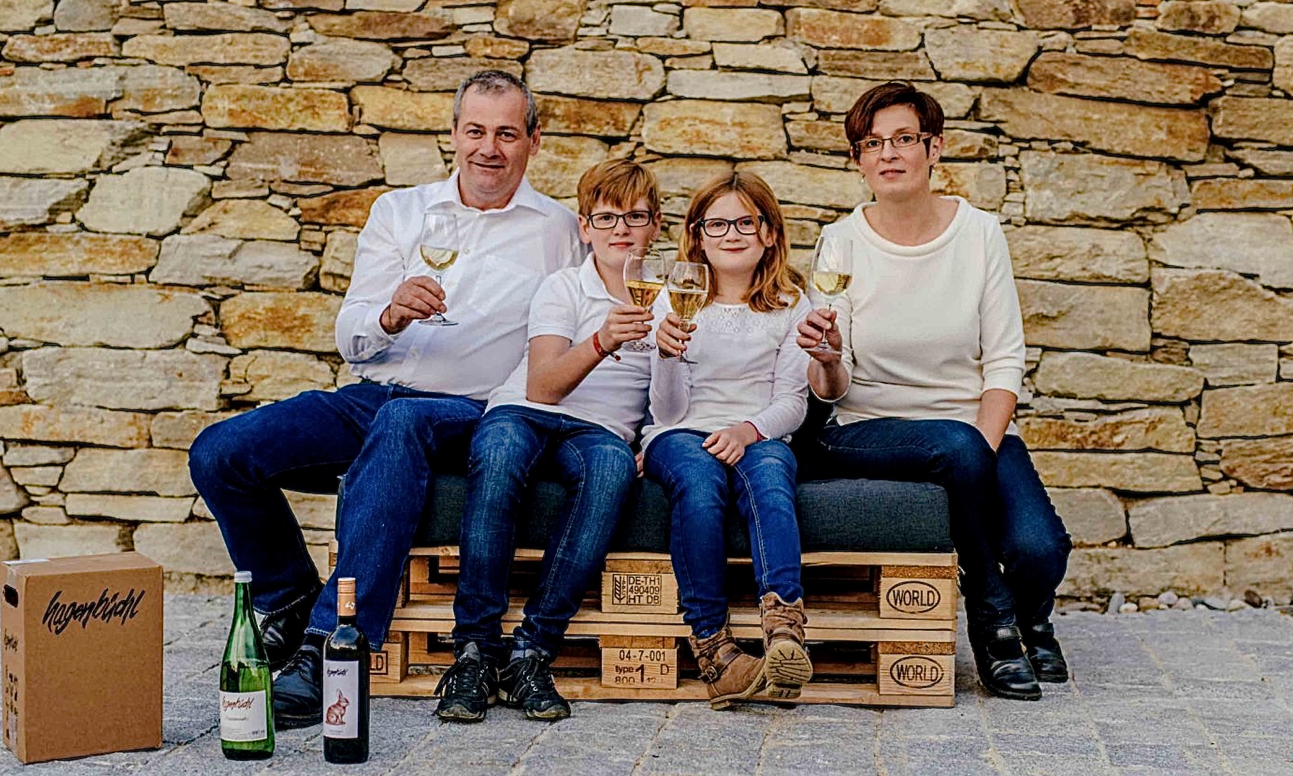Familie, zwei Kinder, mit Wein und Saftgläsern